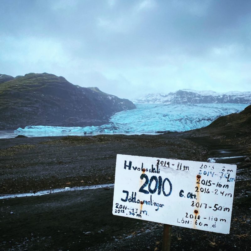 A visual marker of climate change: A sign showing the annual retreat of a glacier.